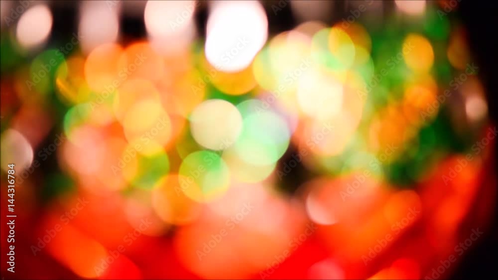 Colorful blurry lights from a glass with burning candles. Moving colorful, blurred light particles background. Colorful blurry lights from a glass with burning candles. Moving colorful, blurred light particles background.