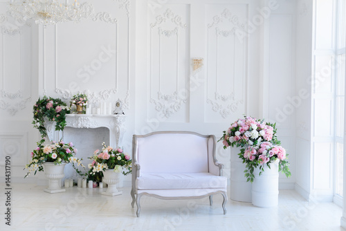 Canvas Print Interior of a snow-white living room with a vintage sofa and flowers