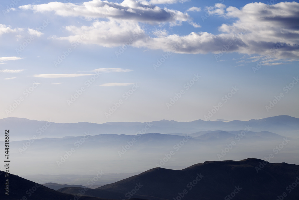 Silhouette of mountains in fog at early morning