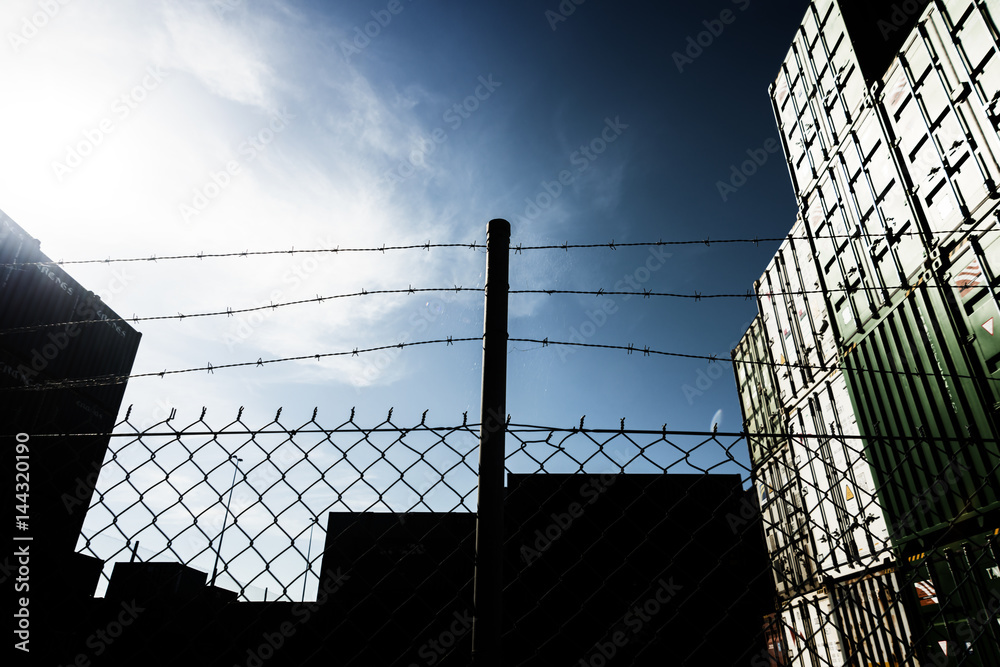 Security fence with shipping containers behind. Security fence with shipping containers behind.