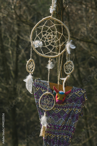 On the tree hanging dream catcher and a woman's dress. Hipster style