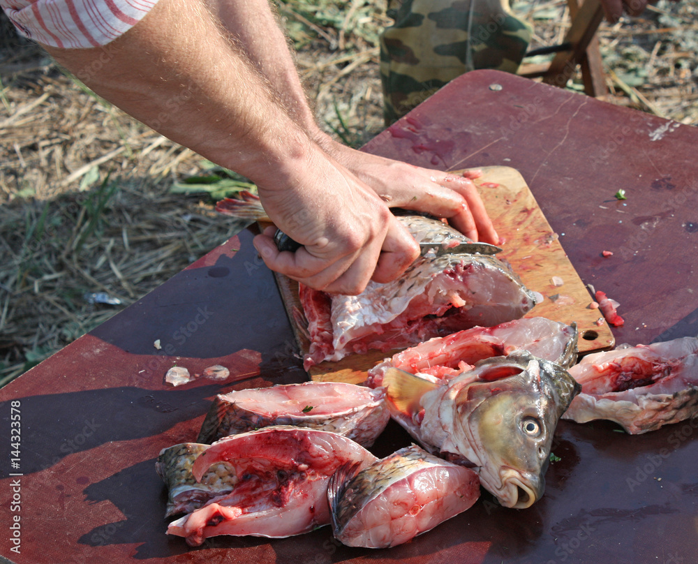 Cutting fish with a knife into pieces