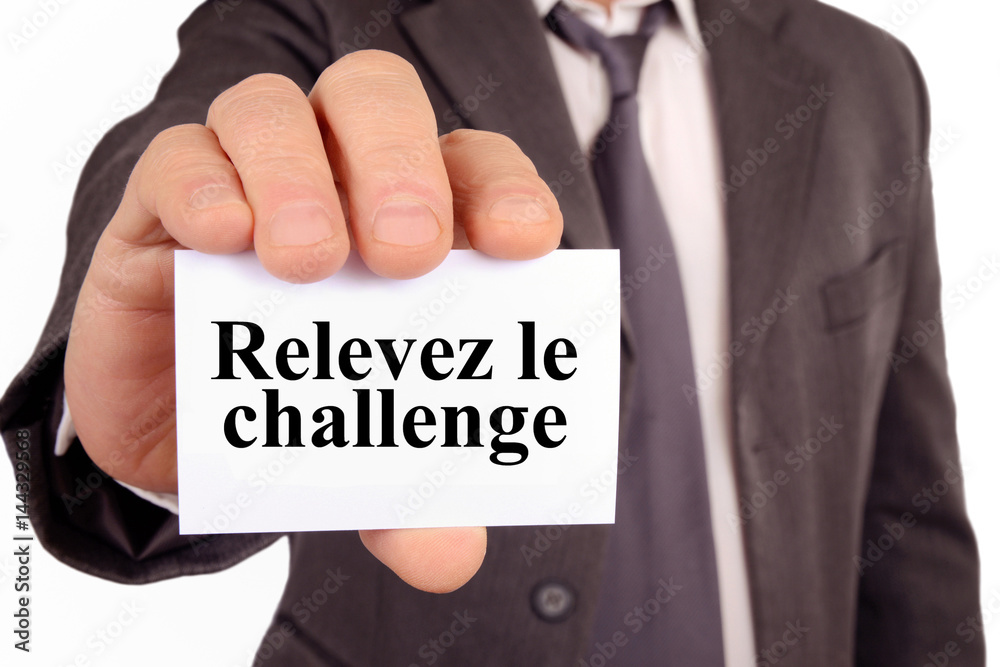 Homme tenant une carte avec relevez le challenge écrit dessus Homme tenant une carte avec relevez le challenge écrit dessus