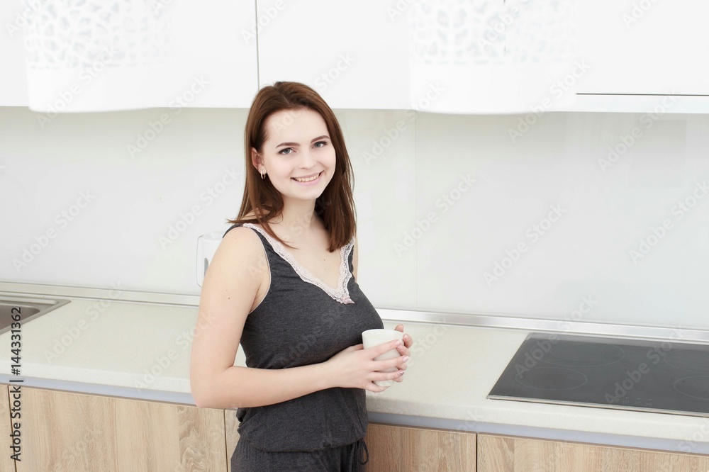 young woman With black hairdrinking coffee in the kitchen