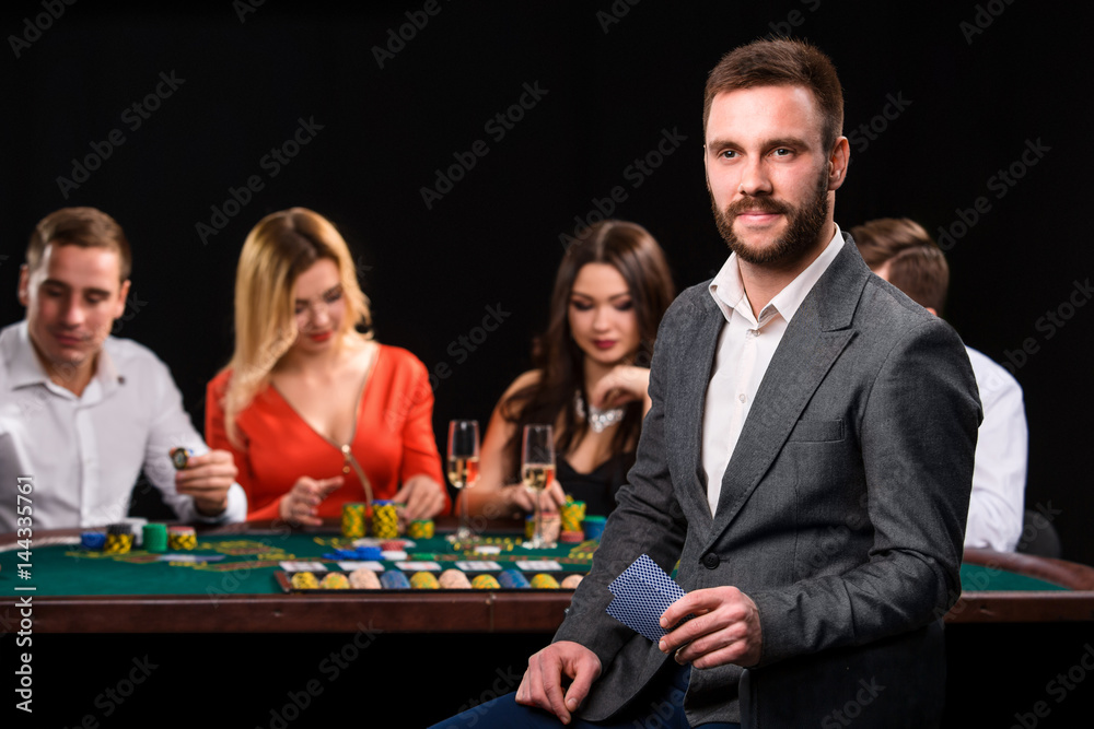 Poker players in casino with cards and chips on black background Poker players in casino with cards and chips on black background