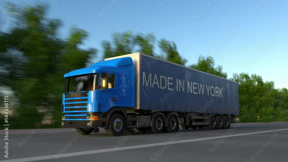 Speeding freight semi truck with MADE IN NEW YORK caption on the trailer. Road cargo transportation. Seamless loop 4K clip Speeding freight semi truck with MADE IN NEW YORK caption on the trailer. Road cargo transportation. Seamless loop 4K clip