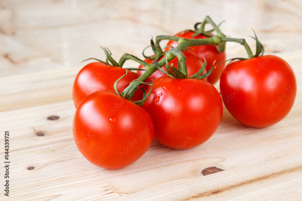 Bunch of fresh organic tomatoes on a wooden background Bunch of fresh organic tomatoes on a wooden background