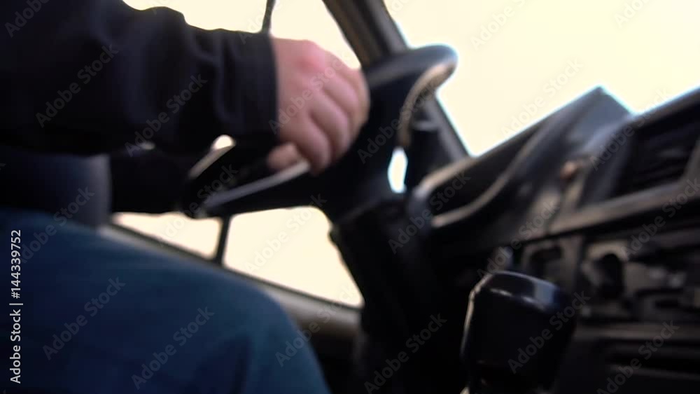 Driver with a bottle of alcohol sits behind the steering wheel Driver with a bottle of alcohol sits behind the steering wheel