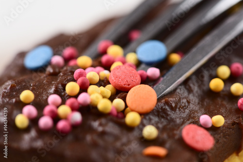 Chocolate icing decorated with milticolored sugar confetti sprinkles