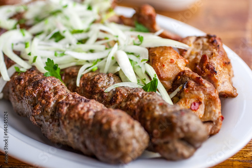 Traditional Georgian mtsvadi pork barbecue and Kebab with onion and parsley