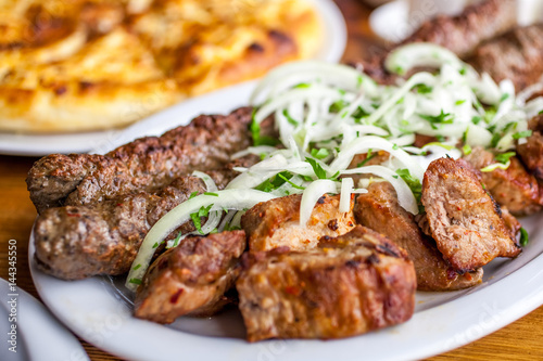 Traditional Georgian mtsvadi pork barbecue and Kebab with onion and parsley