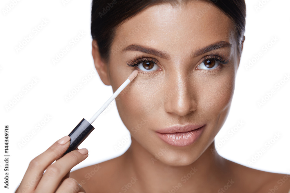 Beautiful Woman Applying Corrector On  Beauty Face. Makeup