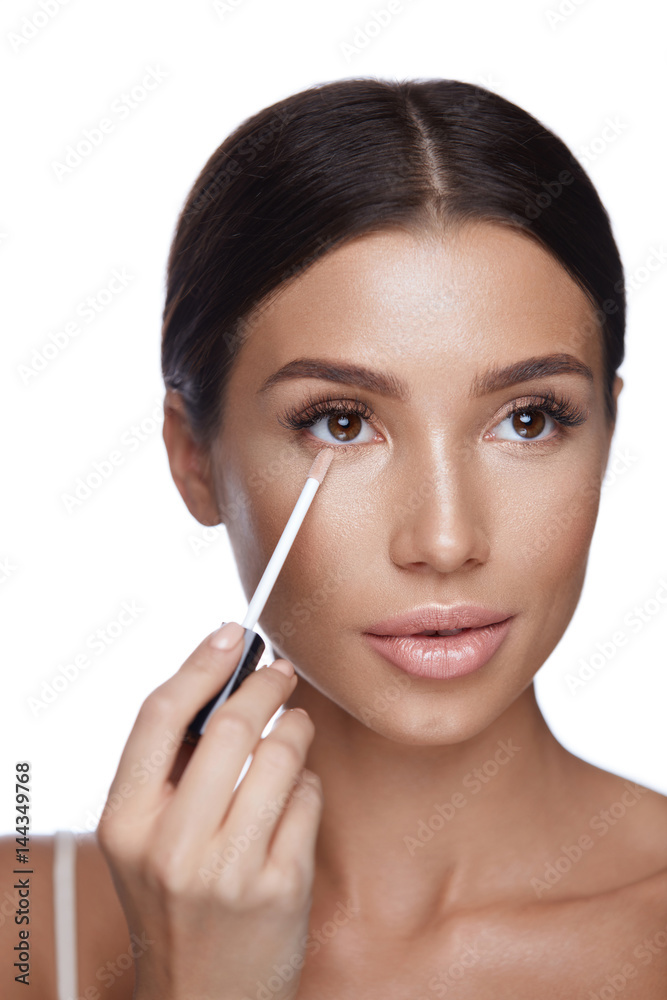 Beautiful Woman Applying Corrector On  Beauty Face. Makeup