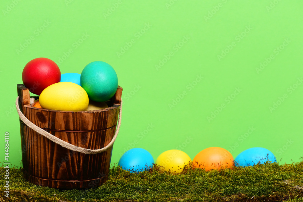 painted easter colorful eggs in wooden bucket with green moss painted easter colorful eggs in wooden bucket with green moss