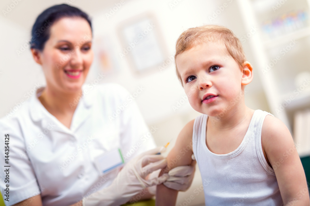 Female pediatrician makes vaccination to small boy Female pediatrician makes vaccination to small boy