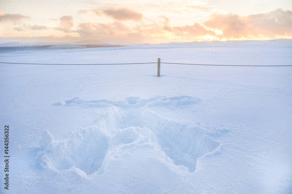 Snow print of human full body shaped on the thick fresh snow with sunset Snow print of human full body shaped on the thick fresh snow with sunset