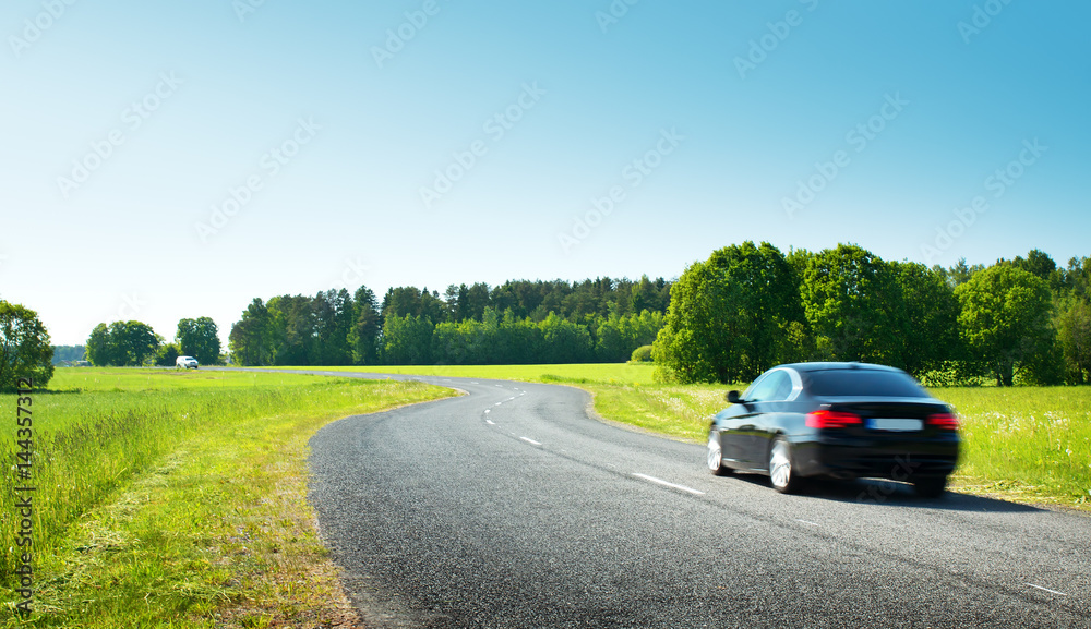 Car on asphalt road in beautiful spring day at countryside