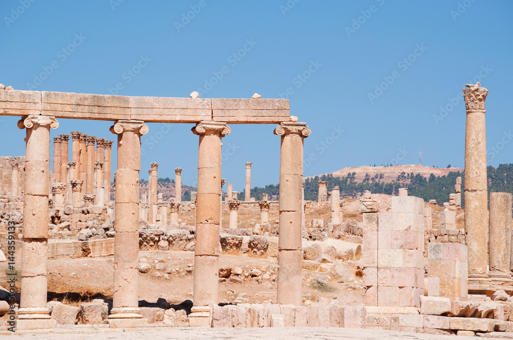 Jerash, Giordania, 04/10/2013: le colonne ioniche del Foro ovale e sullo sfondo le corinzie del Tempio di Artemide nell'antica Gerasa, uno dei siti di architettura romana meglio conservati al mondo