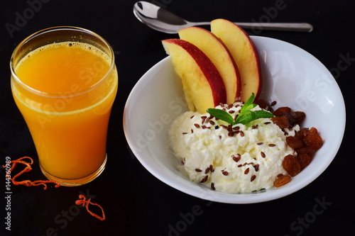 Healthy breakfast: cottage cheese with flax seeds, raisins, fresh apples and a glass of fresh orange juice. Healthy eating concept photo
