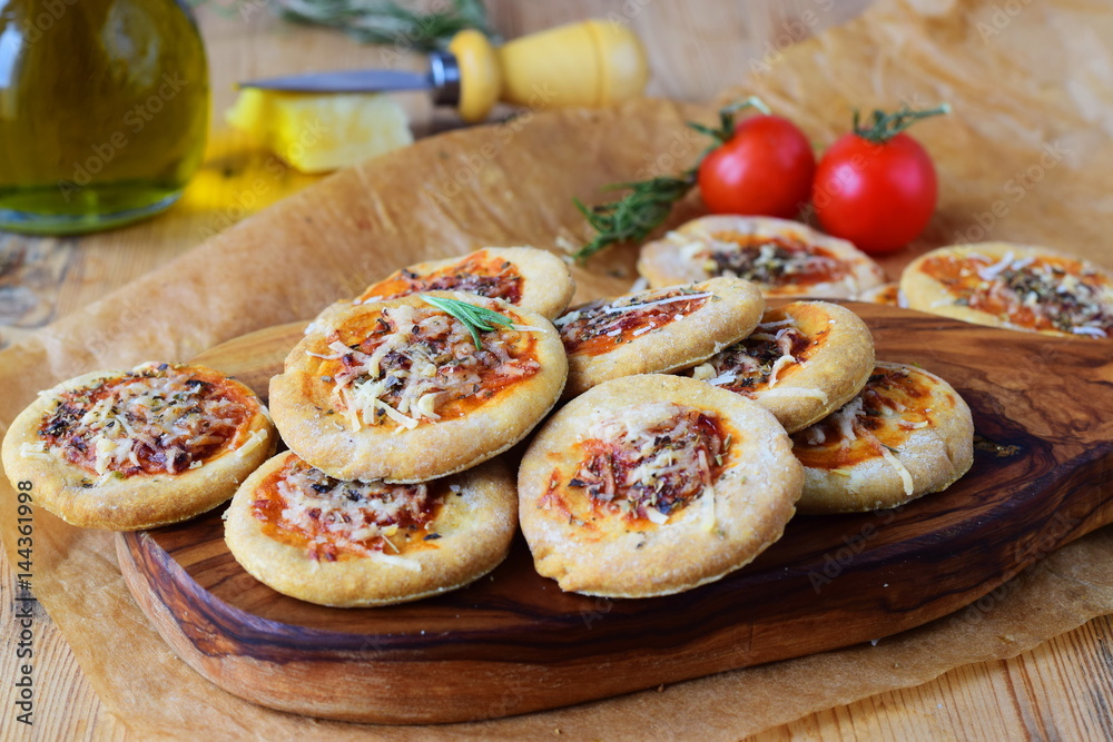 Biscuits in a form of pizza on a wooden cutting board