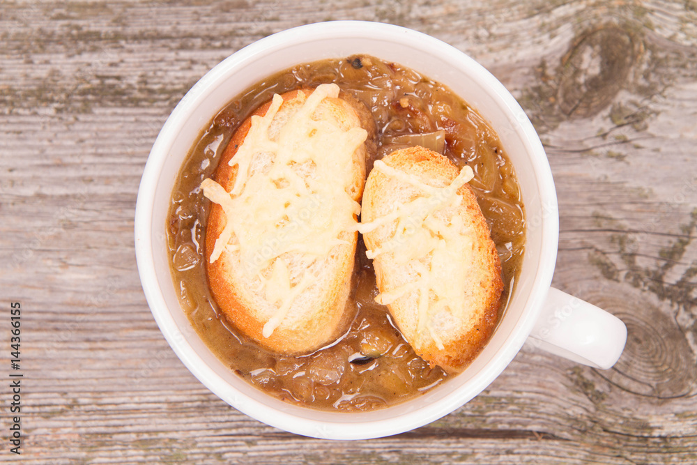 Onion soup with toast on a wooden background Onion soup with toast on a wooden background