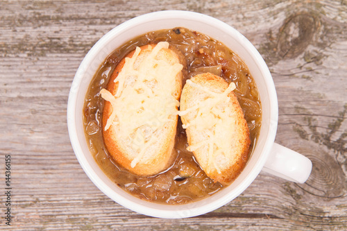Onion soup with toast on a wooden background