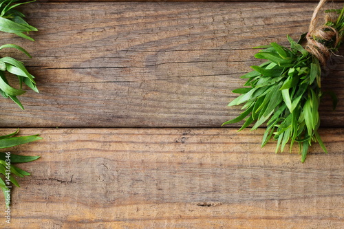 Bunch of fresh tarragon on a wooden background with a space for note