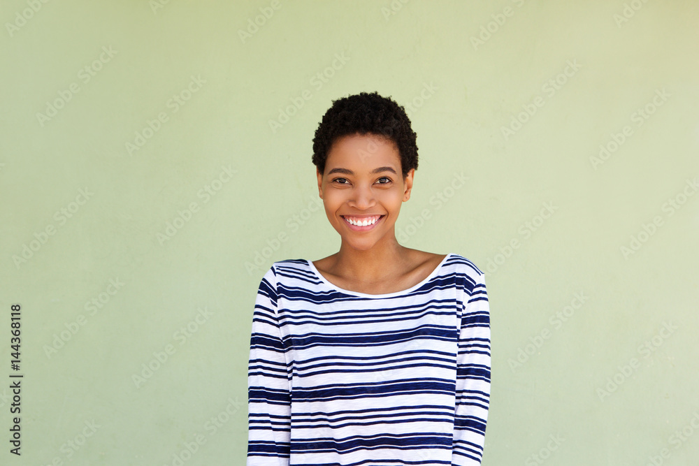 happy black woman in striped shirt smiling by green background happy black woman in striped shirt smiling by green background