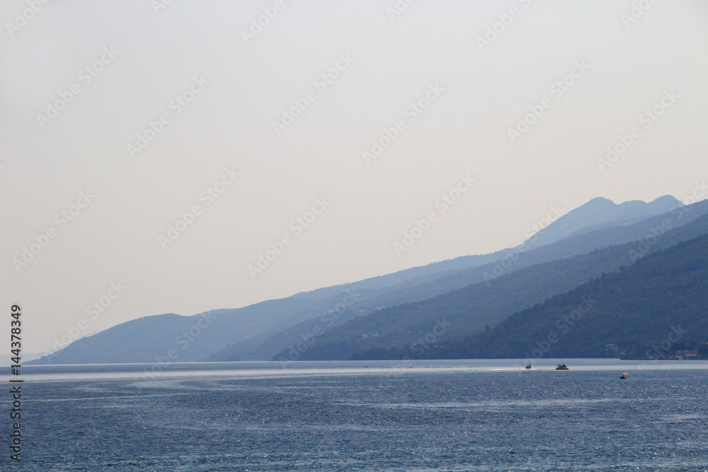 Blue ridges of Istria peninsula, topped with Vojak peak, Ucka mountain, stretch along the horizon over the water of Kvarner Gulf, Adriatic Sea, Croatia, Europe