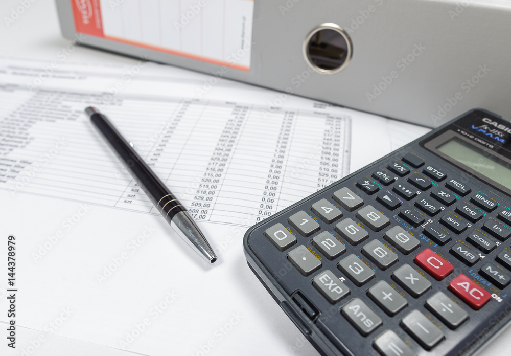 Table with calculator,file binder and pen. Table with calculator,file binder and pen.