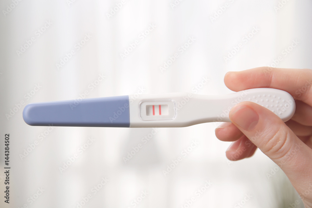 Pregnancy test in female hand on blurred background Stock Photo | Adobe  Stock