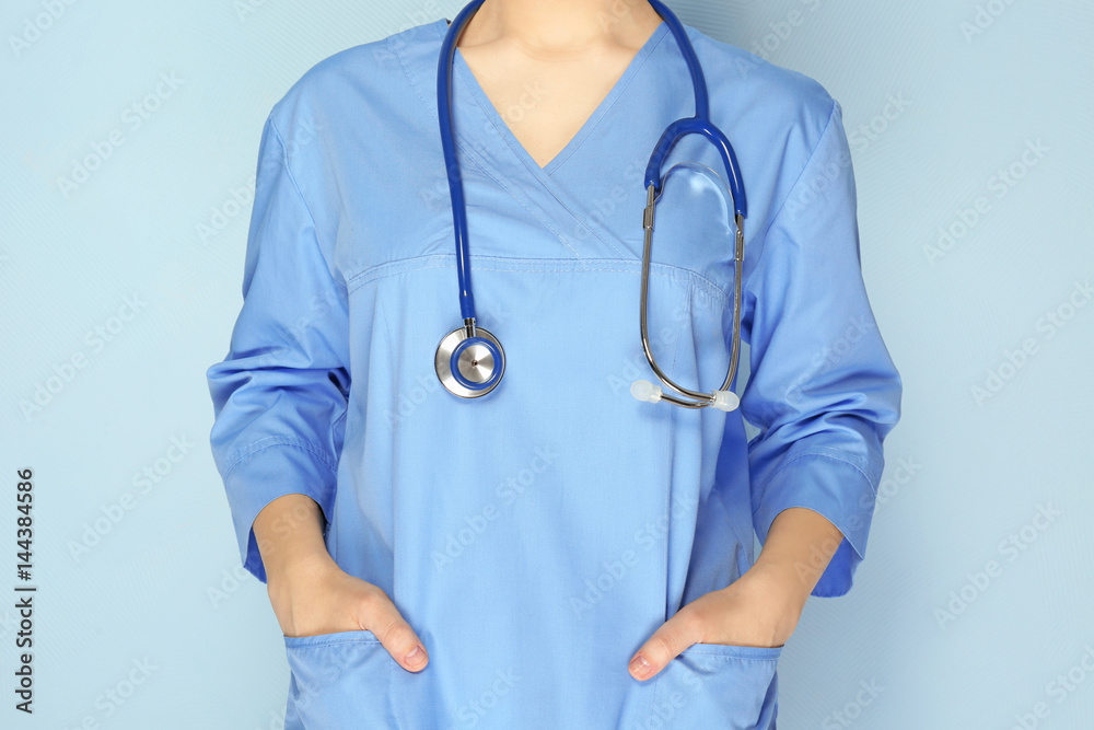 Young medical assistant with stethoscope on color background, closeup Young medical assistant with stethoscope on color background, closeup