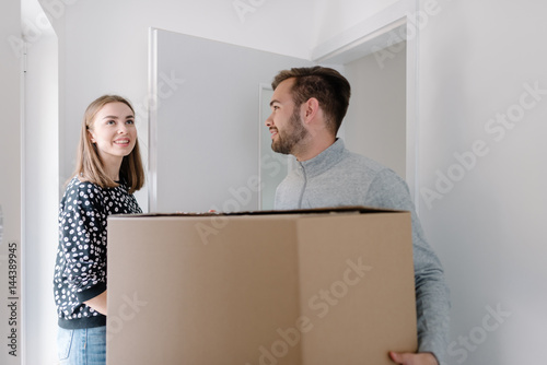 Smiling young woman entering new home with her fiance