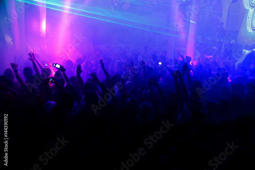 Night club dj party people enjoy of music dancing sound with colorful light with Smoke Machine and lights show. Hands up in the earth. © Alexey Lesik