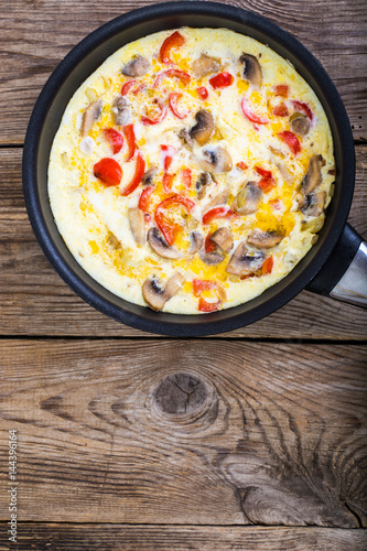 Frittata with mushrooms and peppers in frying pan