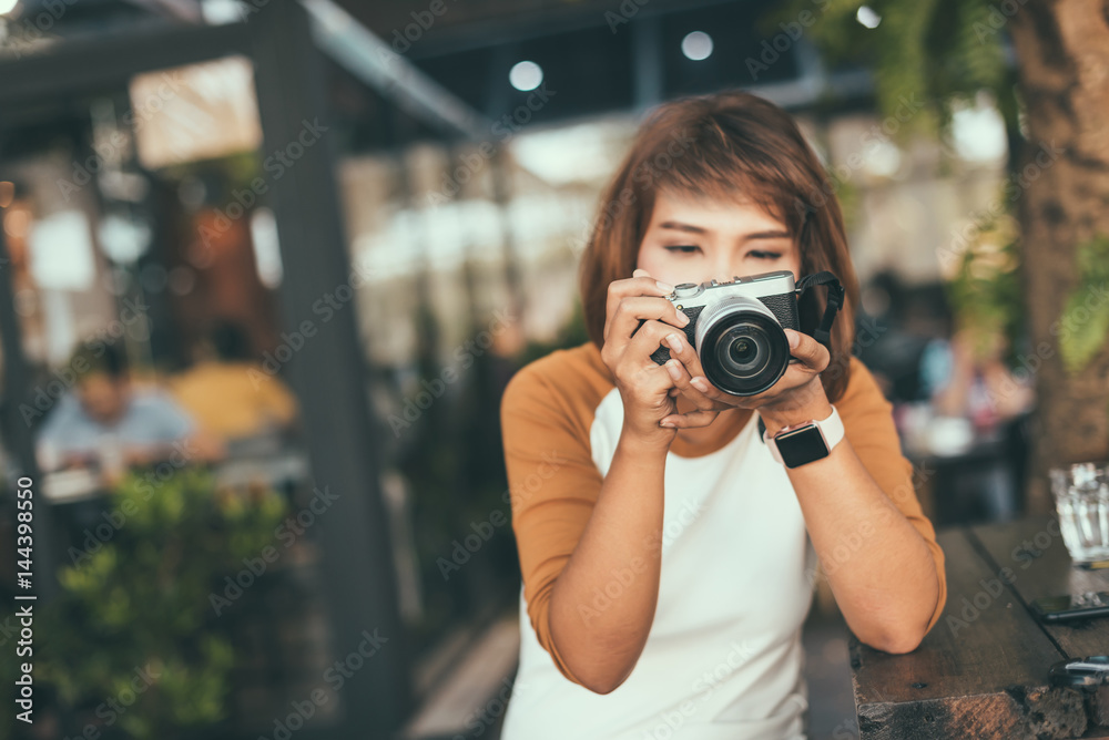 Woman looking at camera's monitor checking pictures taken.