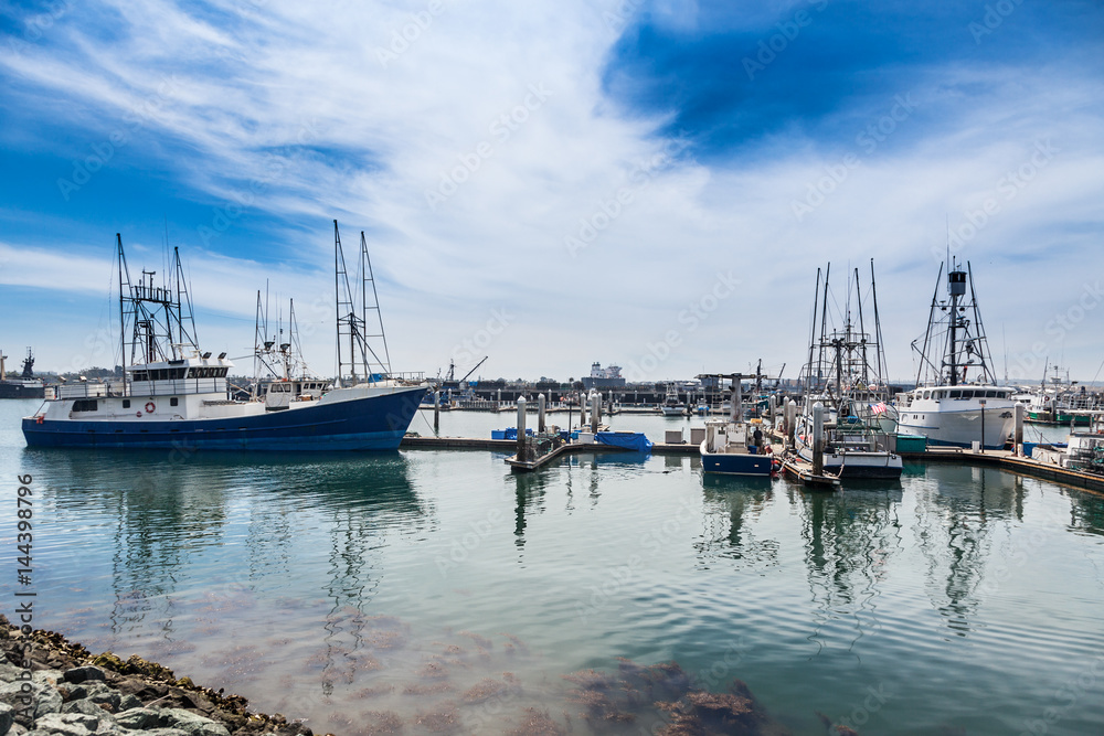 Tuna and other fishing boats docked in San Diego's protected bay with Coronado's bases in the distance