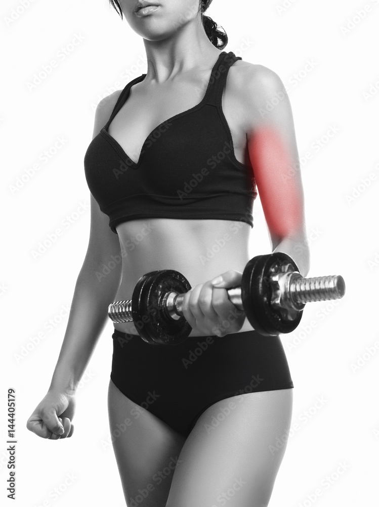 Fototapeta premium beautiful sporty muscular woman working out with dumbbell pain area