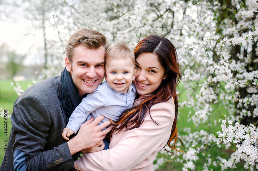 Happy young family walking in a city park Happy young family walking in a city park