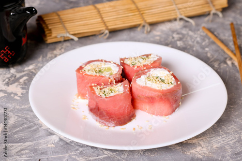 Finger food. Rolls of salmon with cream cheese close-up on the table horizontal