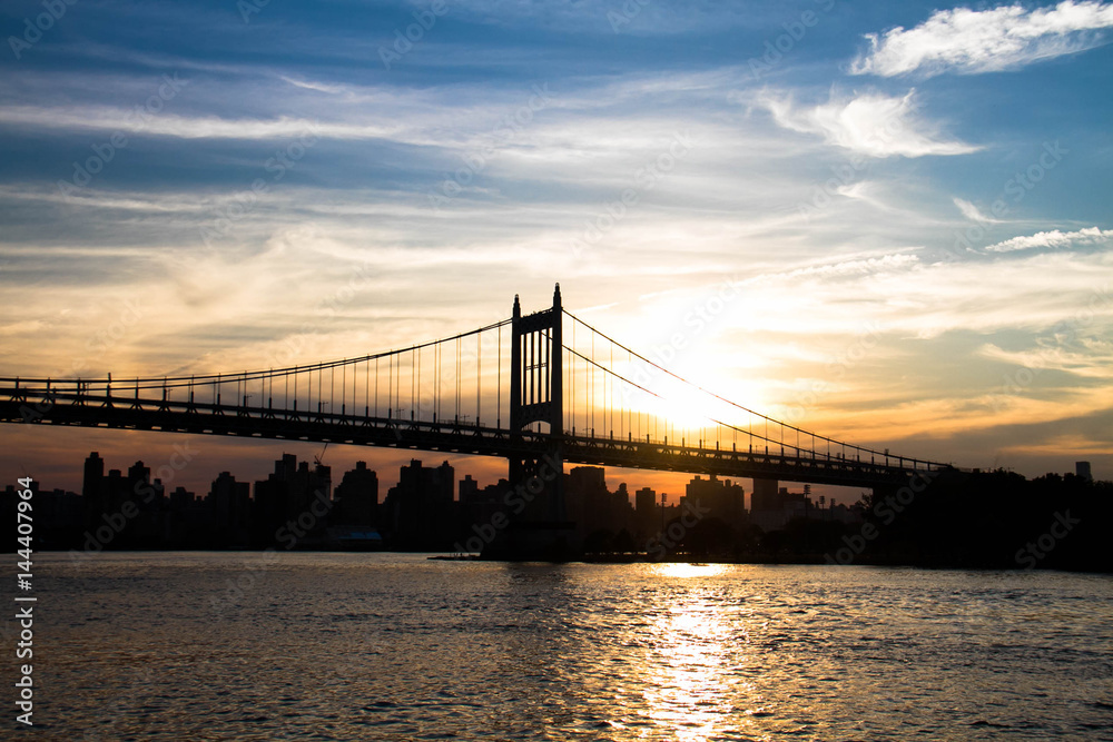 Silhouette of Triborough bridge over the river with sunset sky, New York Silhouette of Triborough bridge over the river with sunset sky, New York