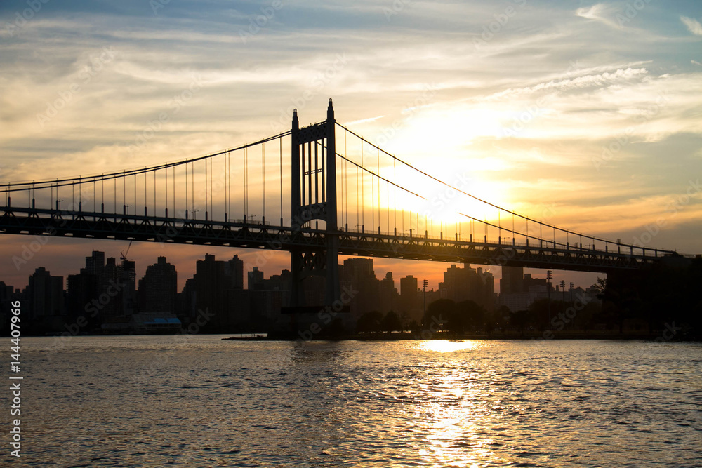 Triborough bridge and city with sunset in silhouette, New York