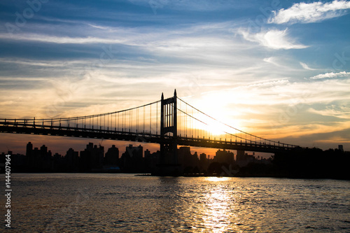 Fototapeta Naklejka Na Ścianę i Meble -  Silhouette of Triborough bridge over the river with sunset sky, New York
