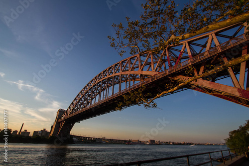 Fototapeta Naklejka Na Ścianę i Meble -  The Hell Gate Bridge over the river with sunset sky, New York