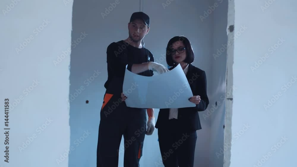 The constructor and investor walking on a site and discussing the blueprint. The constructor and investor walking on a site and discussing the blueprint.