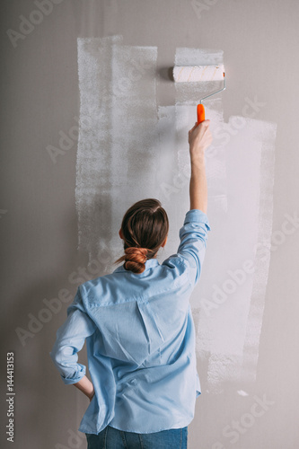 Beautiful young woman doing wall painting
