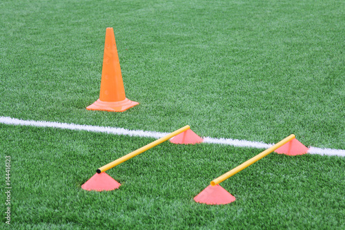 Chips and cone for football training. Sports background with markings on an artificial lawn on a soccer field.