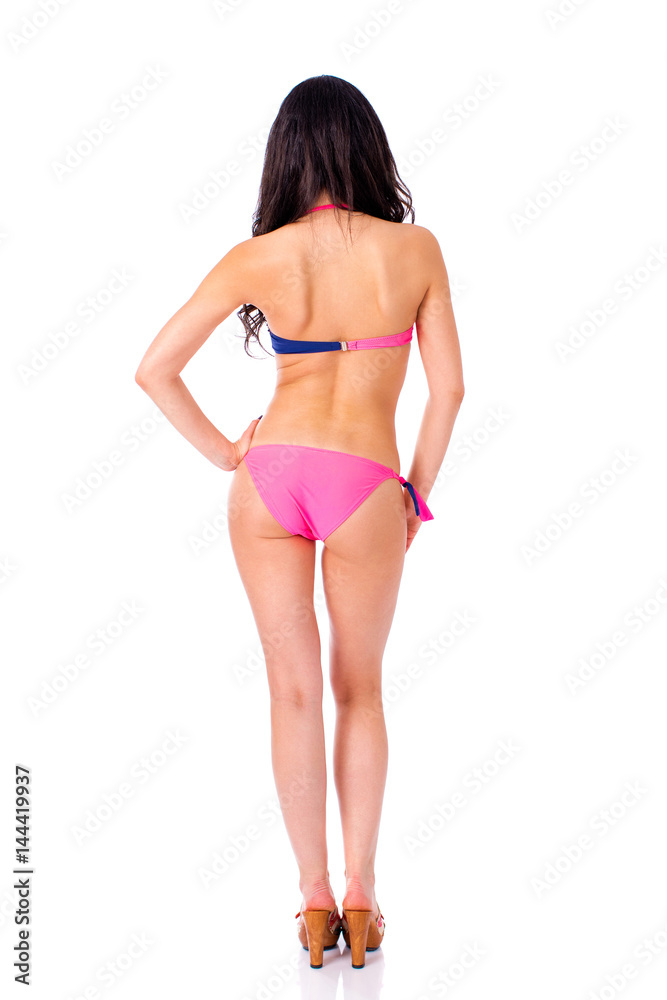 Back view. Snap model. Full length portrait of young woman wearing pink and blue bikini