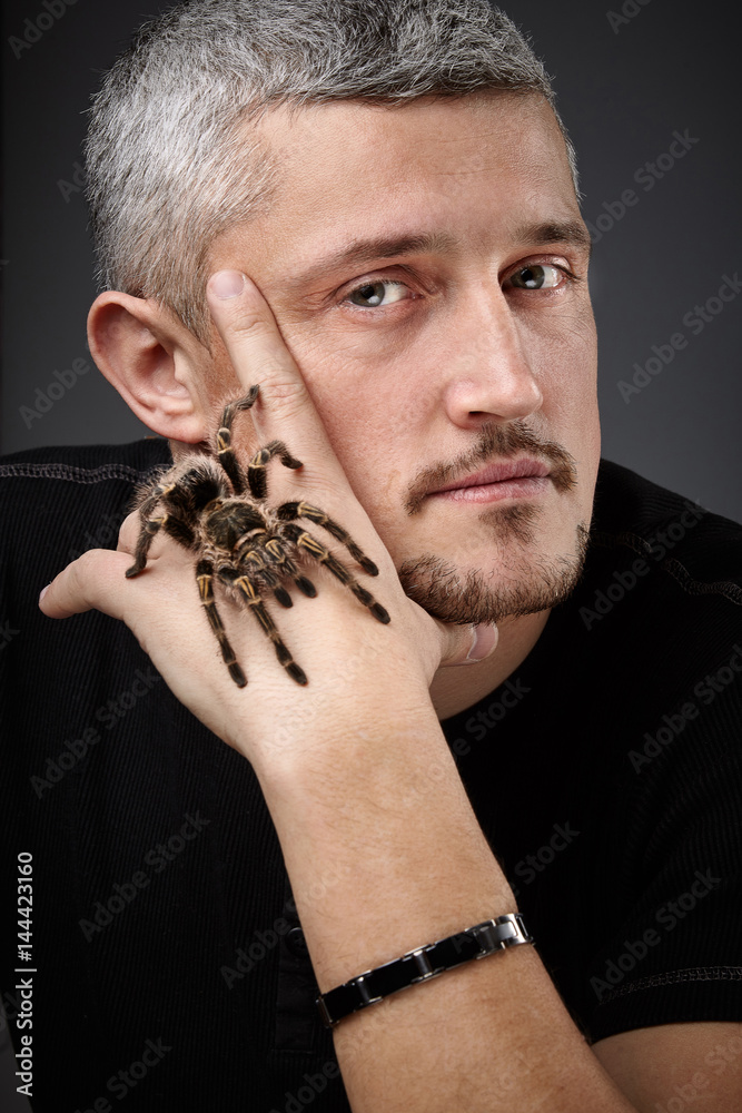 Portrait of a Young Handsome Man with Big Spider on His Hand. Happy and smiling Portrait of a Young Handsome Man with Big Spider on His Hand. Happy and smiling