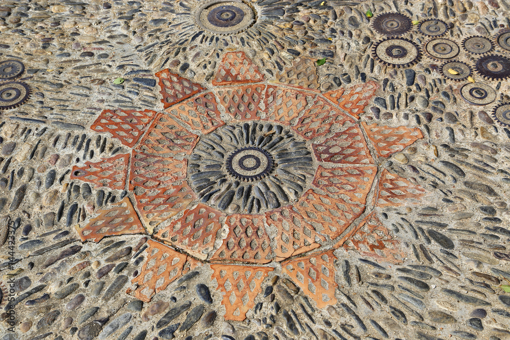 Patterned floor with pattern from pebbles bricks and gears